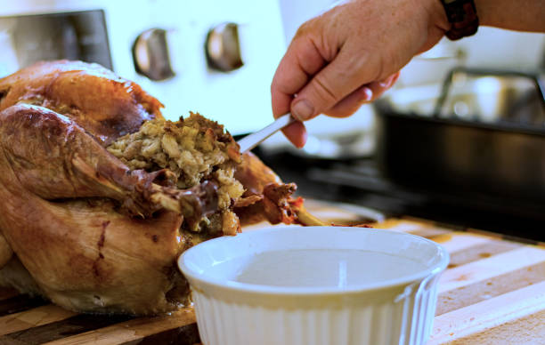 istock Stuffing is removed from the roasted turkey to a serving dish. 1413129722