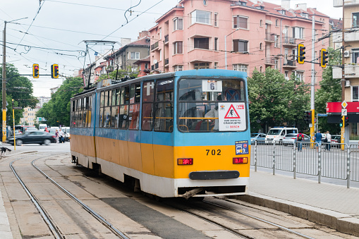 Sofia, Bulgaria - June 6, 2022: Blue and yellow tram on tram stop in Sofia.