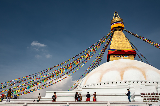 Kathmandu , Nepal - oct 30, 2019:  the golden spire of the Buddhist stupa Boudhanath, adorned with thousands of prayer flags, stands out in the sky of Kathmandu