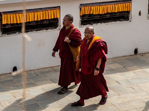 Kathmandu , Nepal - oct 30, 2019:  two Buddhist monks stroll around the Boudhanath stupa in Kathmandu