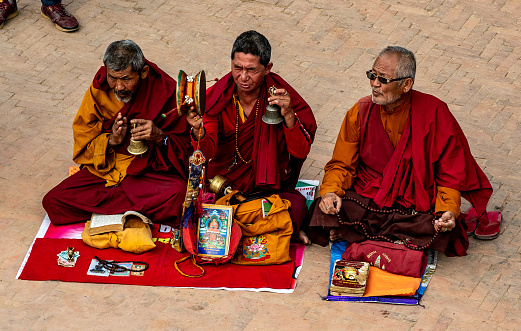 Kathmandu , Nepal - oct 30, 2019: a group of Buddhist monks play and recite mantras in the courtyard of the Boudhanath stupa  in Kathmandu