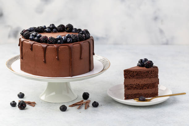 Chocolate cake with fresh berries and sour cream on a white background.