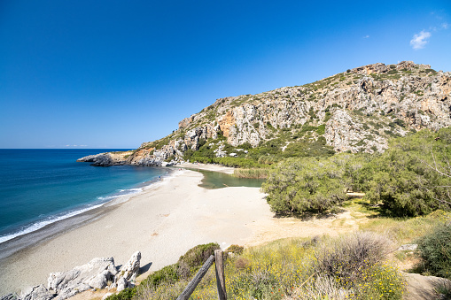 Stunning view of Fteri beach with white sailboat in hidden bay, Kefalonia, Greece. Surrounded by mediterranean vegetation. trekking path. Amazing seascape.