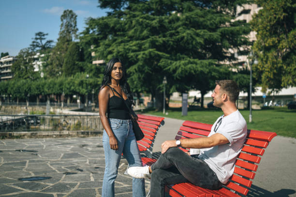 istock Man and woman talk on park bench 1413138340