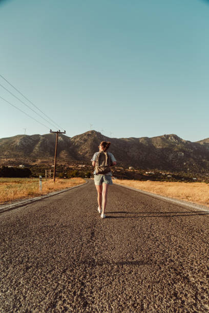 istock Young woman on a country road 1413138366