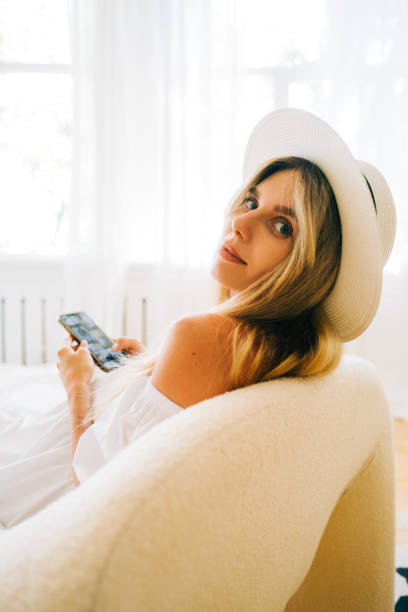 istock young attractive caucasian woman using mobile phone at home and looking back. 1413138848