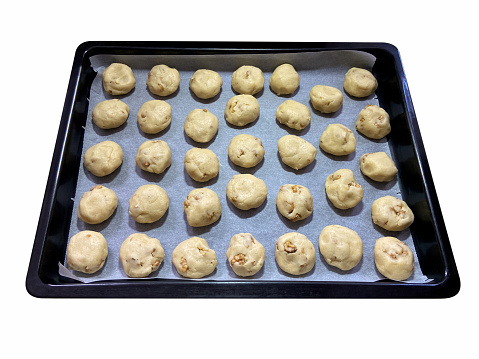 Raw dough homemade walnut cookies in the baking sheet isolated on the white background with clipping path