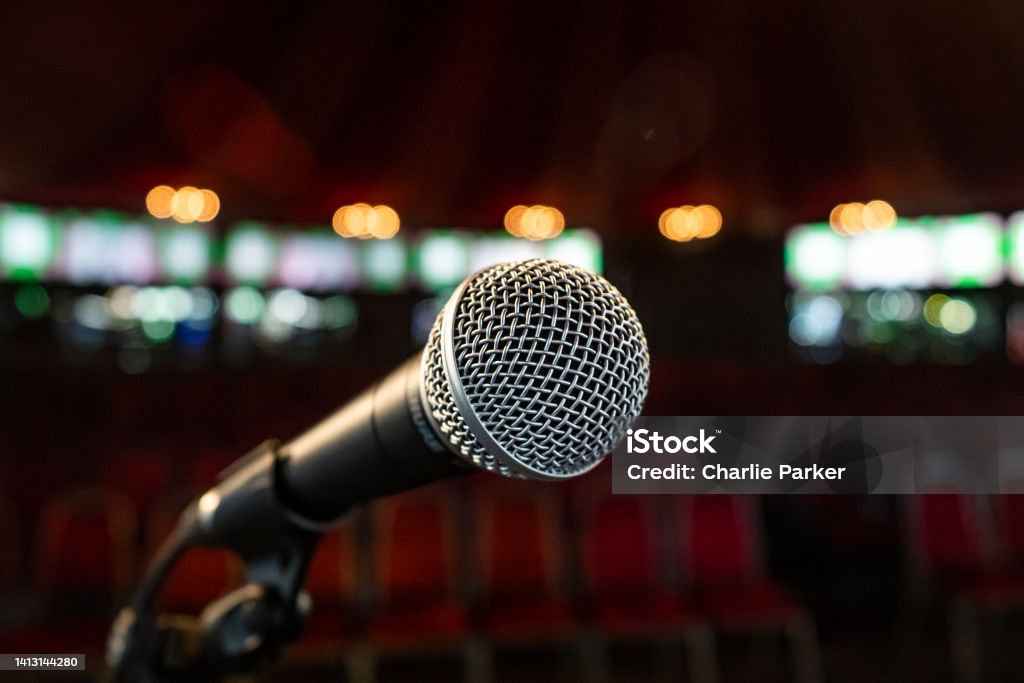 Microphone at Stand-up comedy event in a festival fringe Edinburgh tent 4 A solo microphone stands before an out of focus audience Comedy Mask Stock Photo