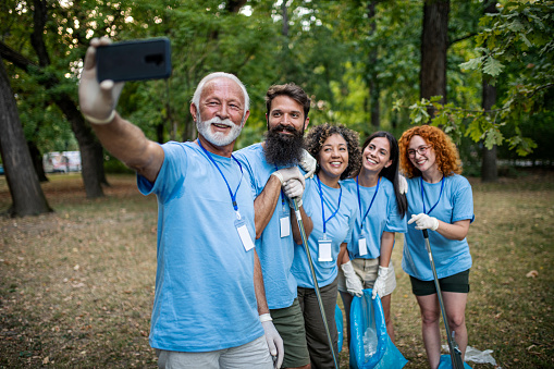 Group of volunteers in the public park making selfie