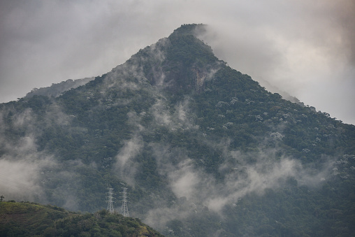The cloud-shrouded Pico do Andaraí Maior peak above the dense Atlantic rainforest of the Tijuca National Park, Rio de Janeiro, Brazil