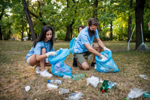 istock Group of volunteers picking up trash and plastic in public park 1413148367