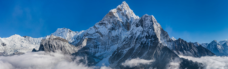 60 MPix XXXXL size panorama of Mount Ama Dablam - probably the most beautiful peak in Himalayas. This panoramic landscape is an very high resolution multi-frame composite and is suitable for large scale printing. Ama Dablam is a mountain in the Himalaya range of eastern Nepal. The main peak is 6,812  metres, the lower western peak is 5,563 metres. Ama Dablam means  'Mother's neclace'; the long ridges on each side like the arms of a mother (ama) protecting  her child, and the hanging glacier thought of as the dablam, the traditional double-pendant  containing pictures of the gods, worn by Sherpa women. For several days, Ama Dablam dominates  the eastern sky for anyone trekking to Mount Everest basecamp