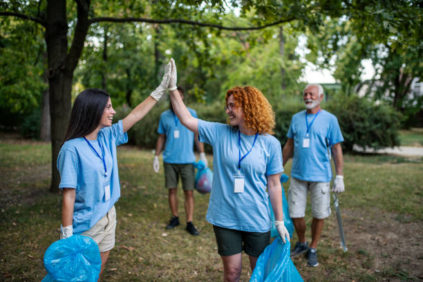 istock Group of volunteers picking up trash and plastic in public park 1413150821