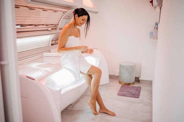 Beautiful woman in solarium. Woman prepares to sunbathe in a solarium tanning bed stock pictures, royalty-free photos & images