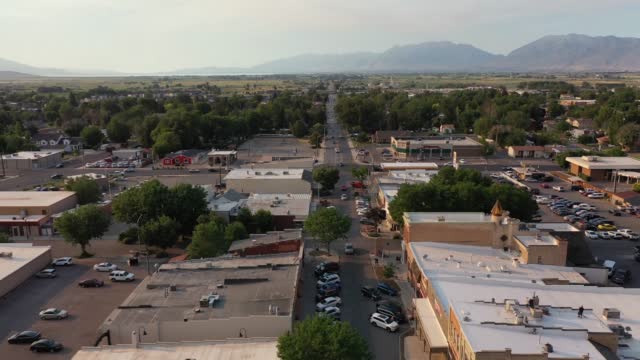 Aerial drone shot of Main Street in rural American town with farms and mountains