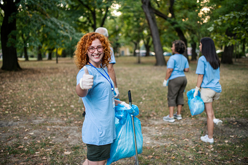 Group of volunteers picking up trash and plastic in the nature