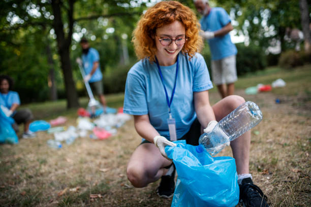 istock Group of volunteers picking up trash and plastic in public park 1413155667