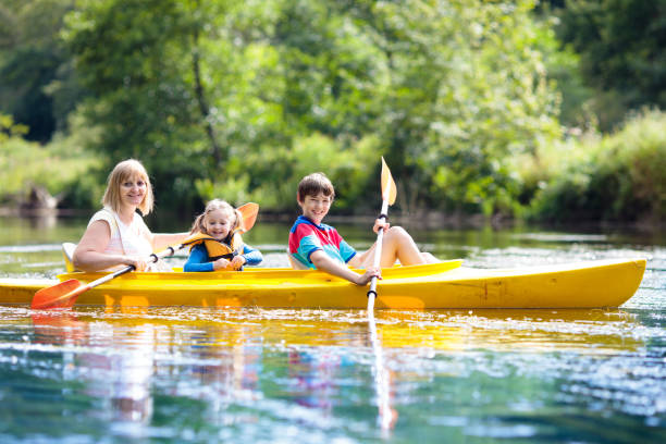 bambino in kayak. bambini in canoa. campeggio estivo. - sailing nautical vessel family lake foto e immagini stock