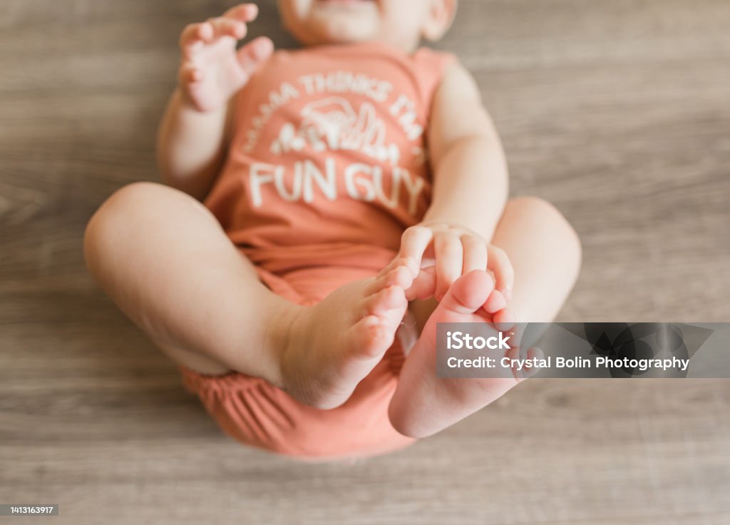 7-Month-Old Baby Boy with 12 Toes Wearing a Coral-Colored Bodysuit That Says " Mama Thinks I'm a Fun Guy" With Mushroom Fungi Depicted Baby - Human Age Stock Photo