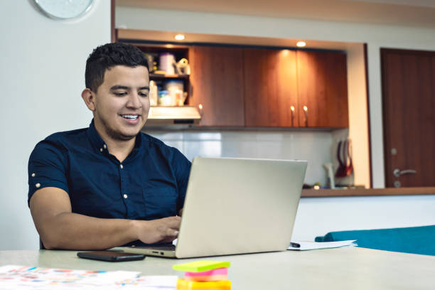 istock Man studying in linear with his laptop sitting in his dining room at home 1413164117