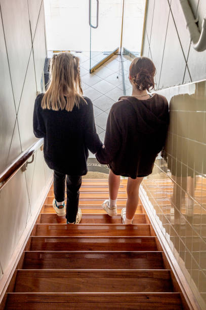 istock Sisters, having re met and embraced, leave  a building together. 1413167524