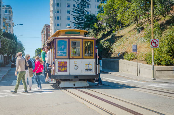 san francisco, kalifornien, usa - 24. juni 2015: seilbahn, eine ikonische touristenattraktion, die einen steilen hügel mit blick auf die gefängnisinsel alcatraz und die bucht hinunterführt - hyde street stock-fotos und bilder