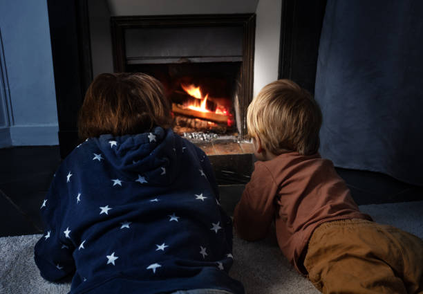 istock Two boys lay in front of the home fireplace look at fire 1413170524