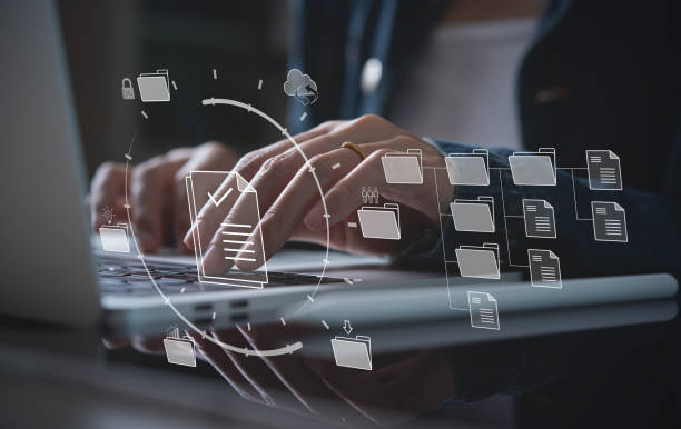 istock Document Management System (DMS) being setup by IT consultant working on laptop computer in office. Software for archiving, searching and managing corporate files 1413178895