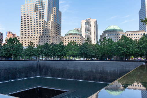 New York City, New York, USA - July 21, 2022: Daytime view of one of the two square reflecting pools on the site of the original Twin Towers of the World Trade Center in New York City. The pools were designed by Israeli-American architect Michael Arad. The museum was dedicated on May 15, 2014.
