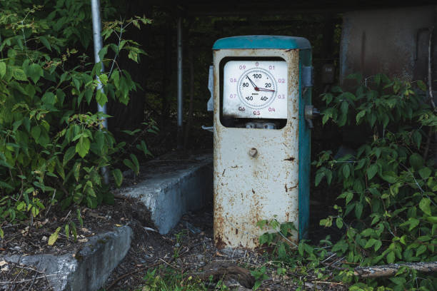 alte rostige verlassene tankstelle mit gras und bäumen bewachsen - old station natural gas russia stock-fotos und bilder