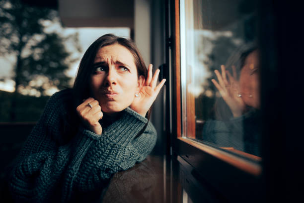 Funny Woman Spying and Eavesdropping on her Roommate stock photo