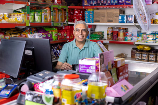 happy senior man travaillant comme caissier au supermarché - grocer photos et images de collection