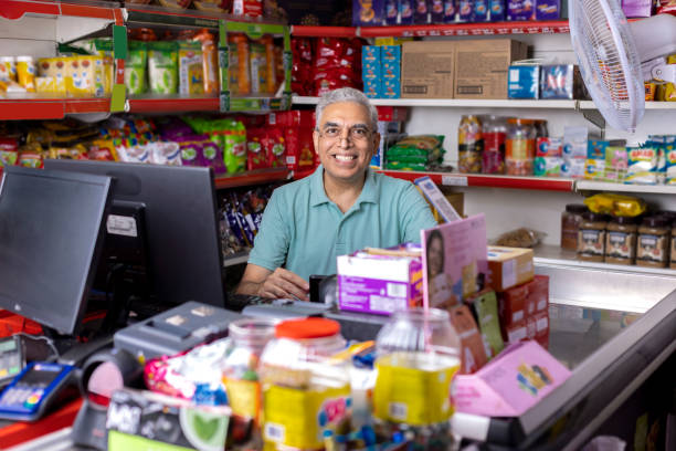 счастливый пожилой мужчина, работающий кассиром в супермаркете - grocer стоковые фото и изображения
