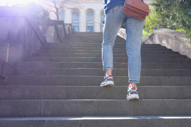 istock Woman in jeans going up steep stairs 1413199461