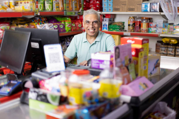 happy senior man travaillant comme caissier au supermarché - grocer photos et images de collection