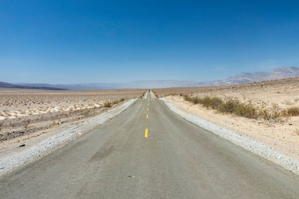 istock empty straight road thru the death valley with yellow median 1413201668
