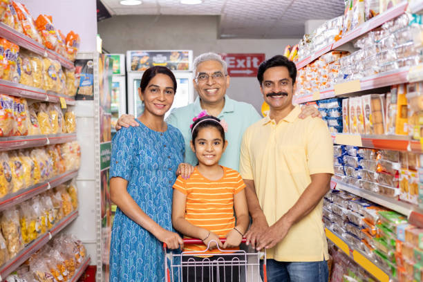 Happy family shopping for groceries at the supermarket Happy indian family shopping for groceries at the supermarket happy indian young family couple stock pictures, royalty-free photos & images