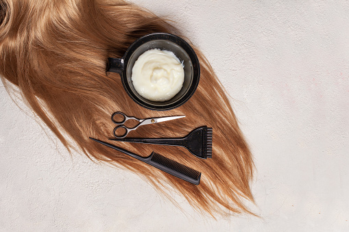 Hair, scissors, comb, brush and hair dye on white background. Hairdresser and barber equipment, top view