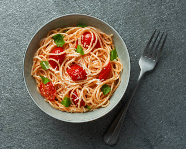 istock Spaghetti with cherry tomatoes top view on grey slate background 1413208952