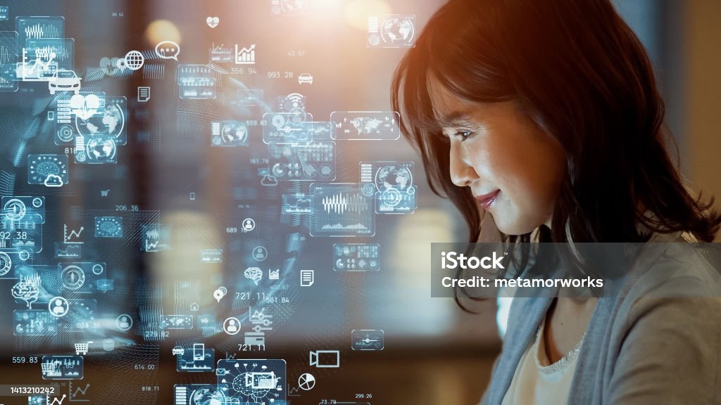 Asian woman watching hologram screens. Business and technology concept. Smart office. GUI (Graphical User Interface). Artificial Intelligence Stock Photo