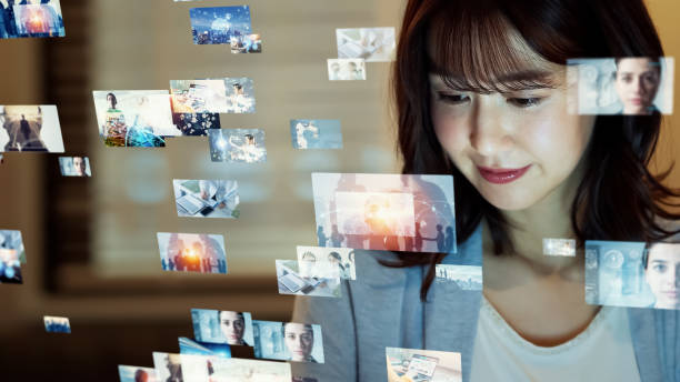 asiatische frau, die hologramm-bildschirme beobachtet. konzept der visuellen inhalte. social-networking-dienst. video-streaming. kommunikationsnetz. - medienberuf stock-fotos und bilder