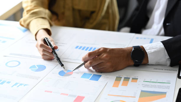 istock Two business colleagues are checking and analyzing financial data in corporate office. Cropped view. 1413210346