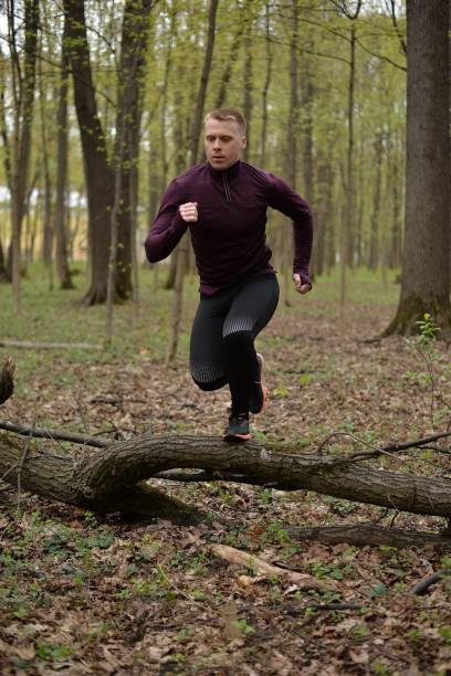 istock A man jumps over a branch. 1413210357