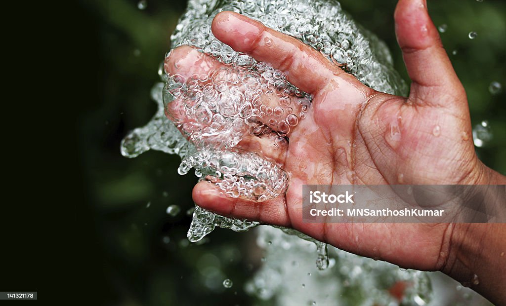 Fresh pure bubbling water splashing on hand Fresh clean and pure bubbling water splashing on hand Below Stock Photo