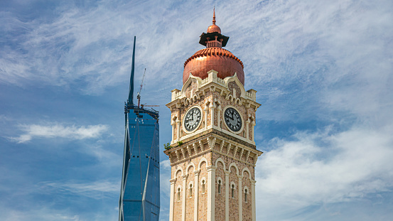 Kuala Lumpur, Malaysia - June 12, 2022: Old and new icon of the malaysian capital. The clock tower of Sultan Abdul Samad Building and the new second tallest building in the world, Merdeka 118 or KL118