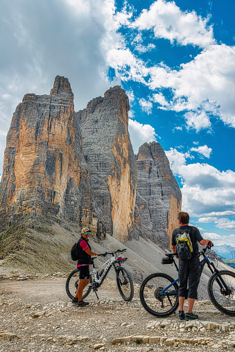 Mountain bikers in front of the famous three peaks of Lavaredo, in Dolomites, Italy