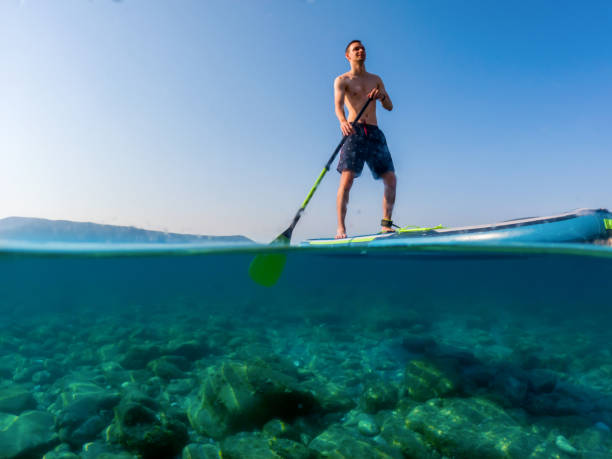 istock Young man on a paddleboard on the sea in summer 1413215175