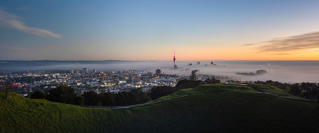 Panoramic view of Sky Tower and Auckland city in the fog, from Mount Eden summit.