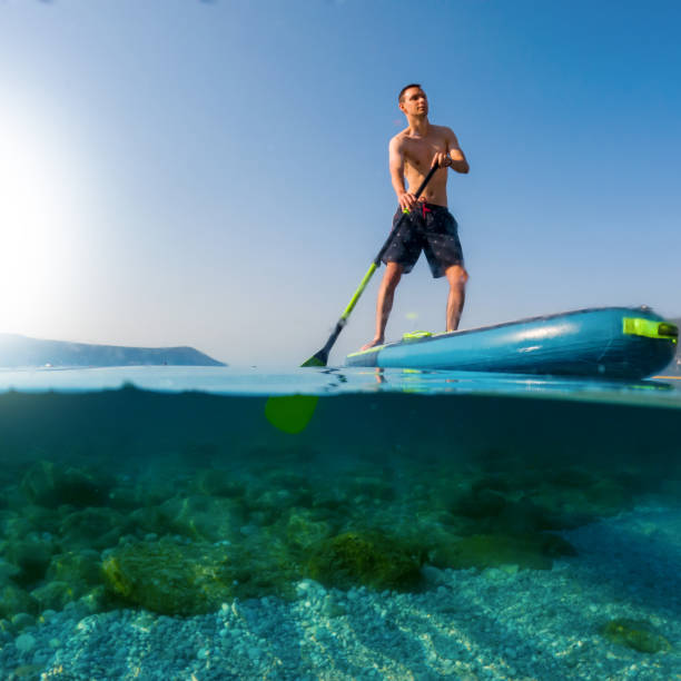 istock Young man on a paddleboard on the sea in summer 1413220821