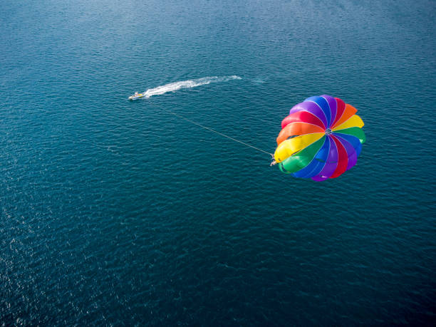 Aerial view of the boat and parachute in the sea resort Aerial top view of the boat and parachute in the sea resort parasailing stock pictures, royalty-free photos & images
